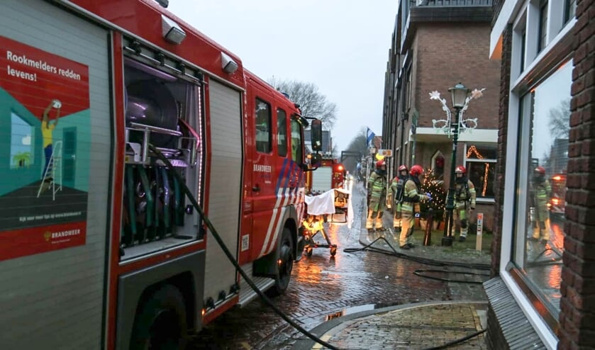 De brandweer aan de slag bij de brand in de Hellingstraat. 