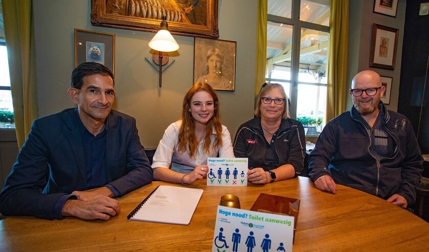 Wethouder Maarten Hoelscher, Marjolein Groen, Hanneke Postman en Frank Wiegers met de toegankelijkheidssticker.