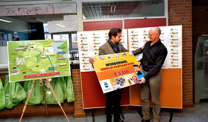 Jorrit Nuijens reikt de cheque uit.