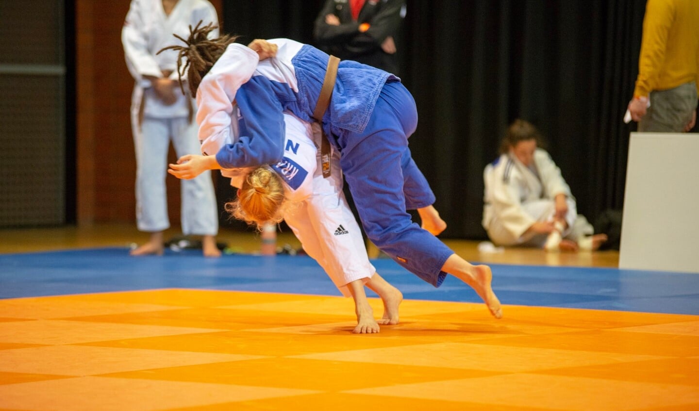 Nadiah in het wit zet een worp in tijdens het NK Judo -21.