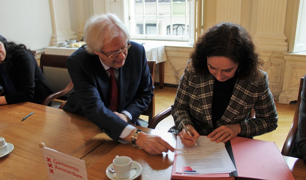 De burgmeesters Femke Halsema en Bas Jan van Bochove ondertekenen het bestuursakkoord die de fusie van beide steden bezegelt.