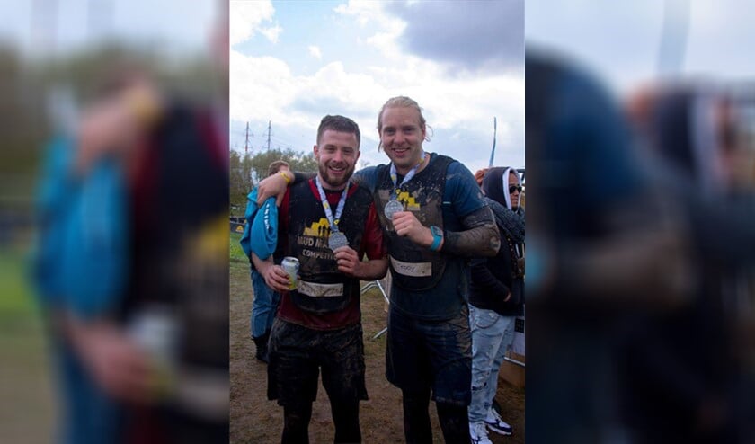 Quintus Sluijter (links) is blij met de opbrengst na de zware mudrunmarathon.