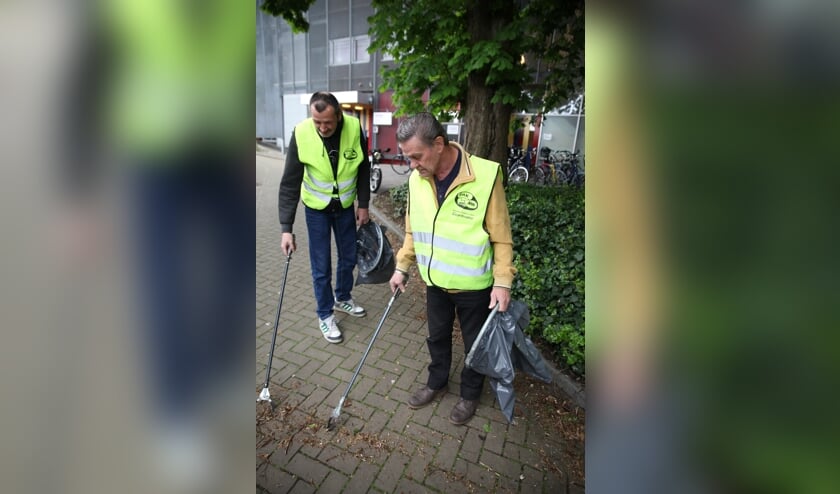 Een deelnemer en een vrijwilliger gaan bijvoorbeeld weer vuilprikken.