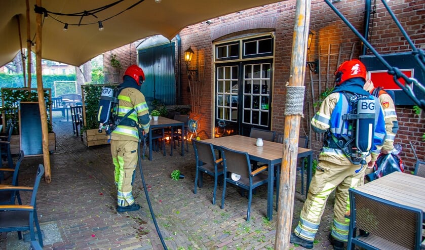 De brandweer blust de plantenbak.