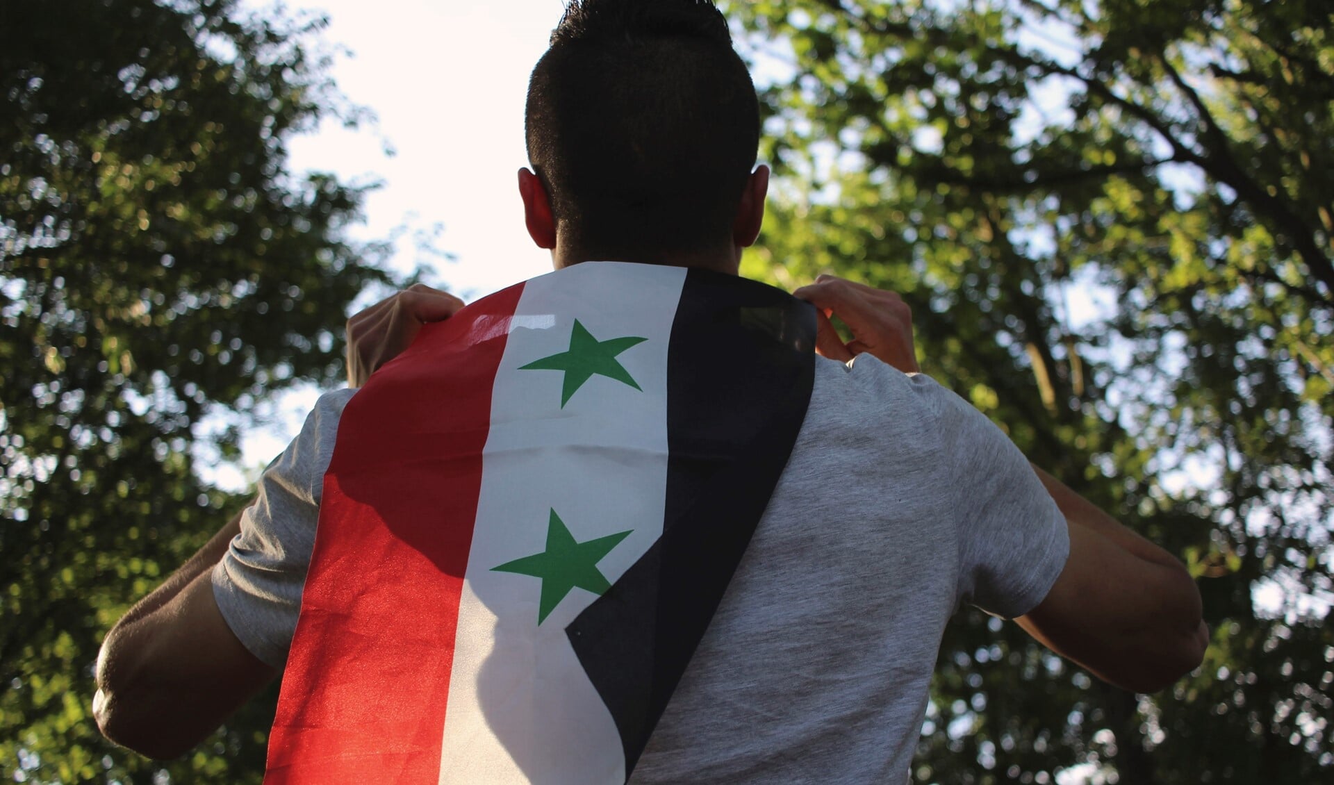 Een man met de vlag van Syrië.