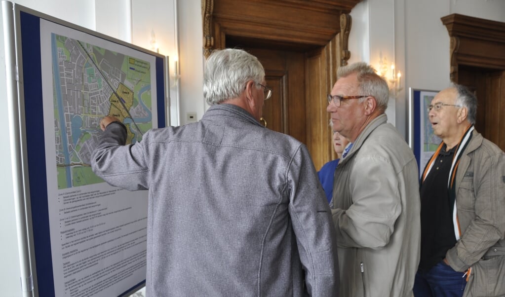 Inwoners bekijken de kaart waarop de gebieden van betaald parkeren staan aangegeven.