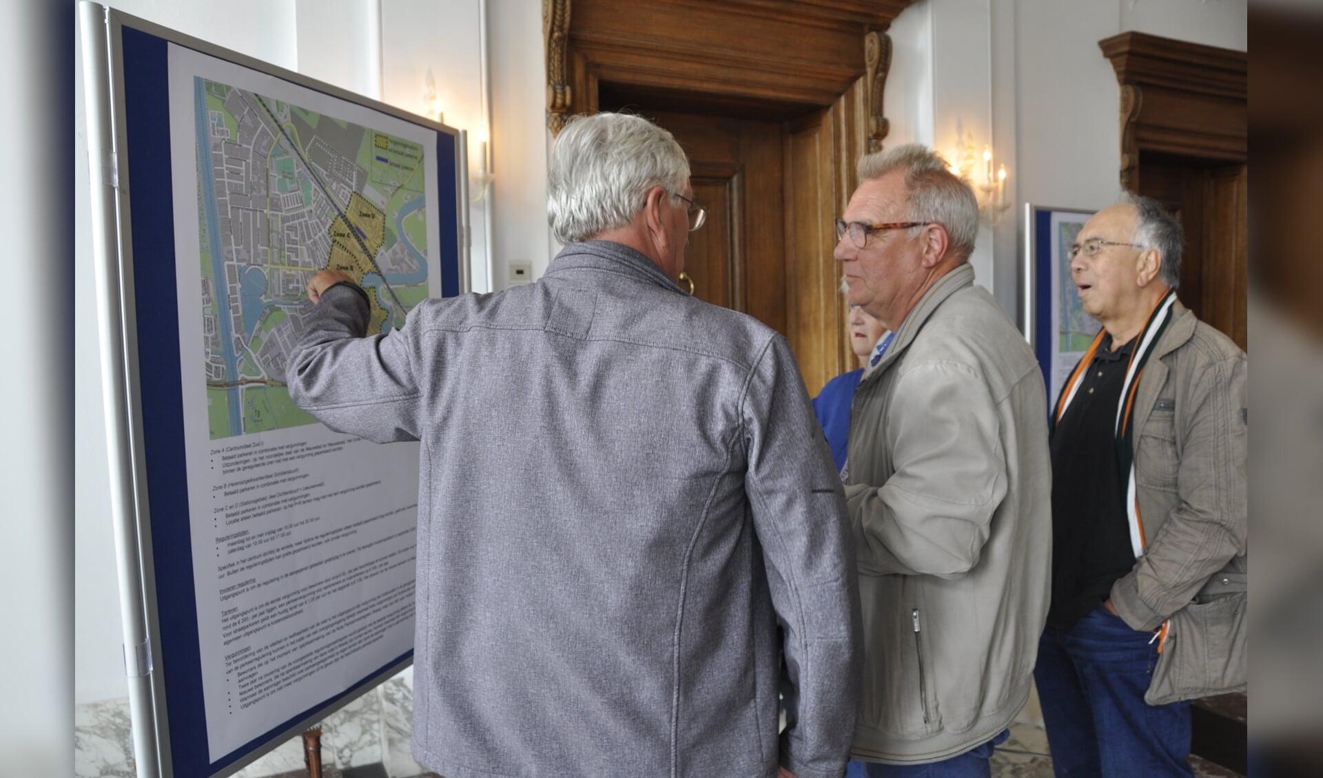 Inwoners bekijken de kaart waarop de gebieden van betaald parkeren staan aangegeven.