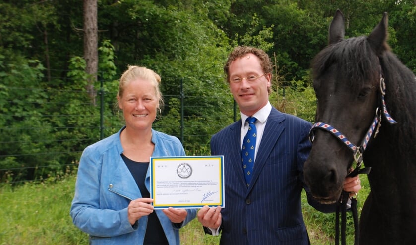 Lisette Bakker ontvangt de cheque van Jasper. Het paard Yfke is al langer bij de manege.