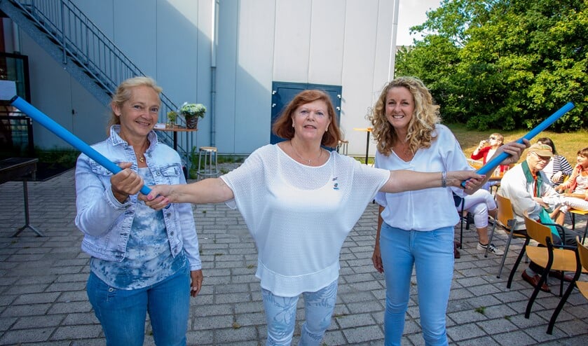Henny Vos (midden) draagt het stokje over aan Let de Groot (l) en Linda Kooij (r).