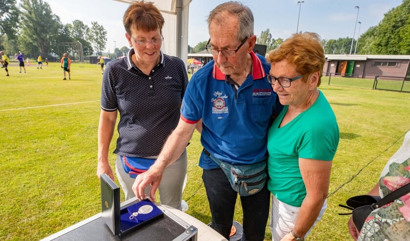 Oud-voorzitter Appie Knol en zijn vrouw bekijken de Erepenning. Knol was tevens eregast tijdens het toernooi.