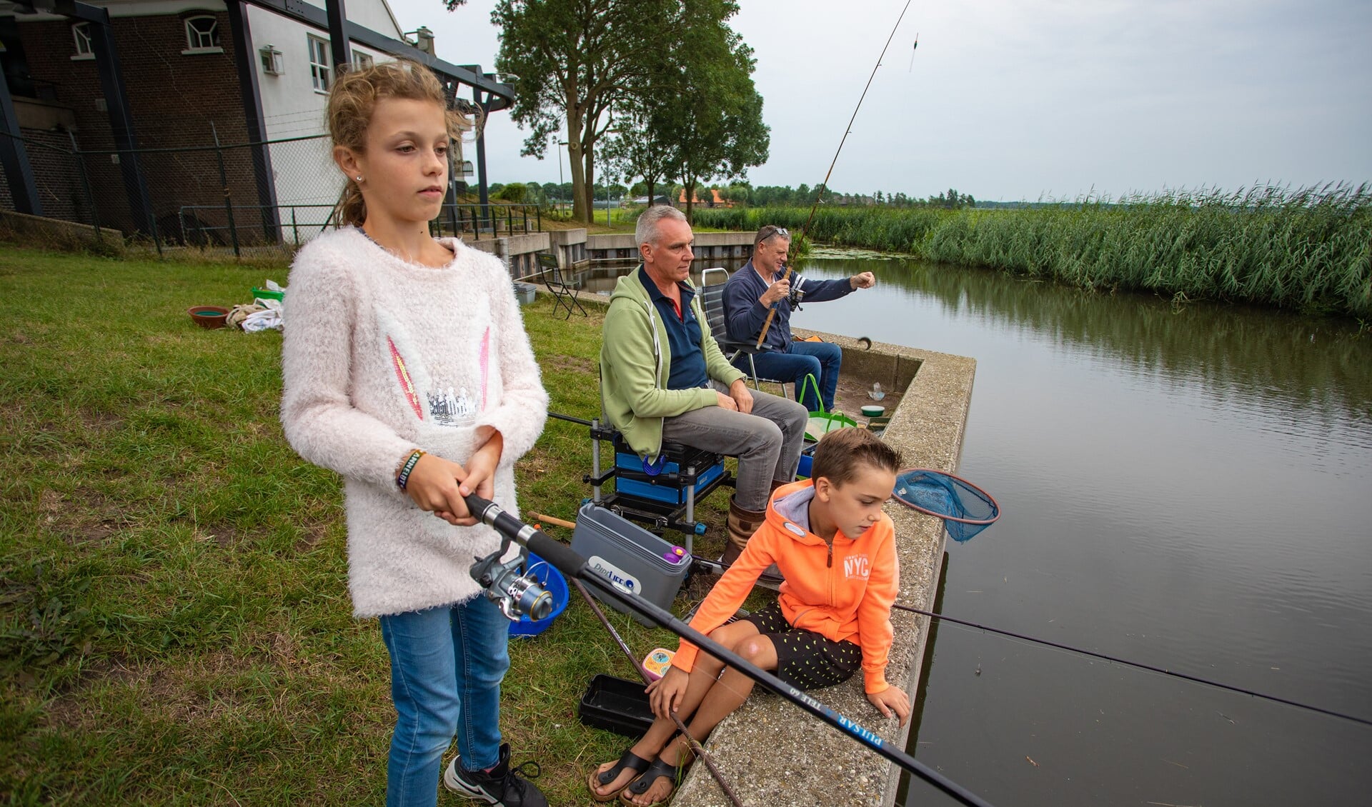 Annelot en Marijn gaan vaak met hun vader Gerlof mee vissen, net als vriend Hans Kaarsgaren (r).