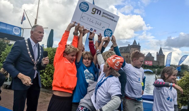 De opbrengst is bekend. Links de burgemeester die ook twee kilometer zwom.