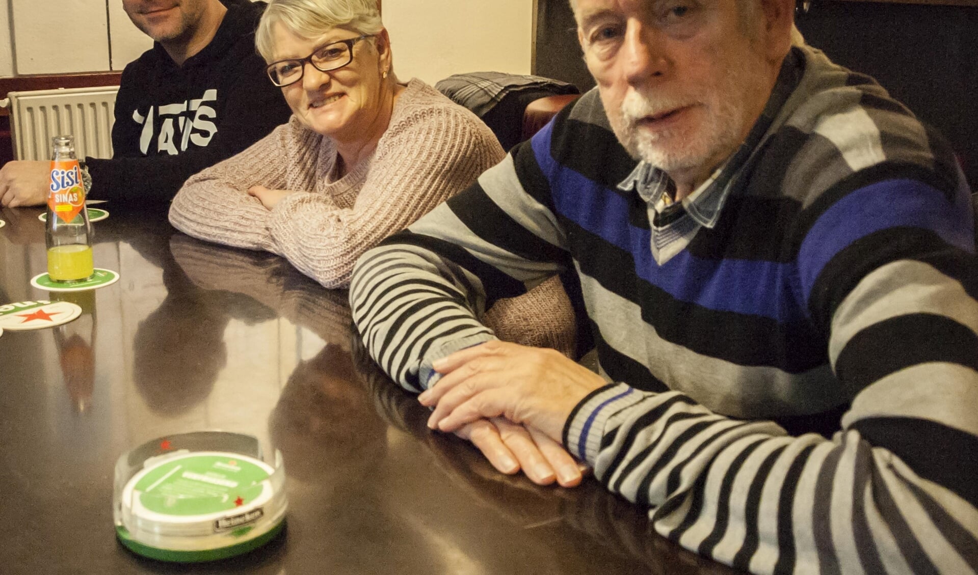 Jan Raaijmakers (rechts) aan de bar van de biljartclub. 