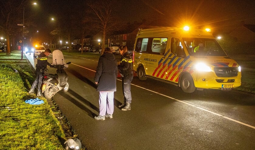 De politie bekijkt de scooter die betrokken was bij het ongeval.