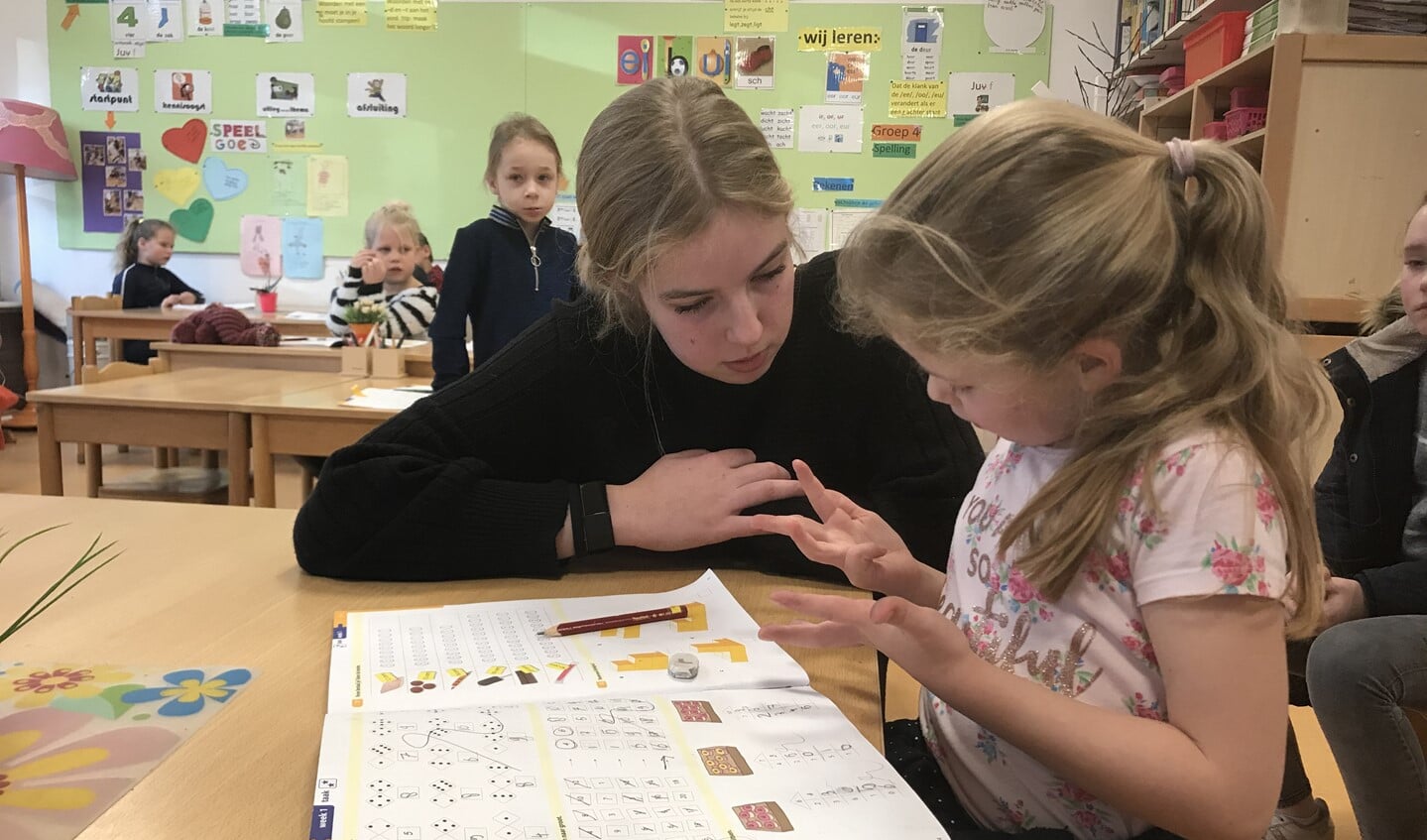 Kim van Hamersveld helpt leerlingen in groep 3/4 met rekenen.