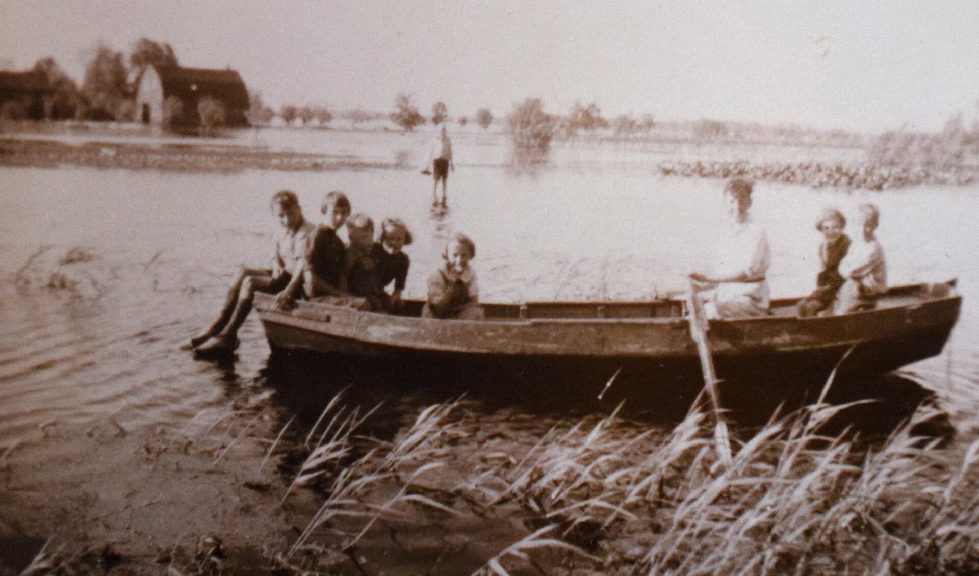 Kinderen uit de familie Van der Wurff dobberen in een bootje op ondergedoken weilanden aan het begin van de Tweede Wereldoorlog. 

