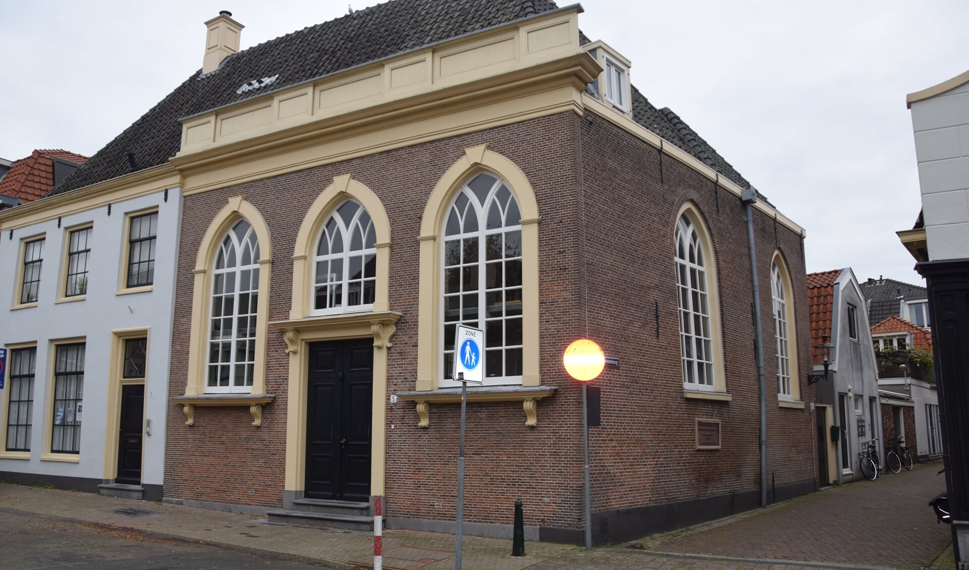 De Weesper Synagoge aan de Nieuwstraat. Aan de stand van de regenpijp is te zien dat de muur is gaan bollen.