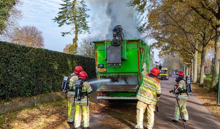 <p>De brandweer probeert de brand in de vuilcontainerwagen te blussen.</p>