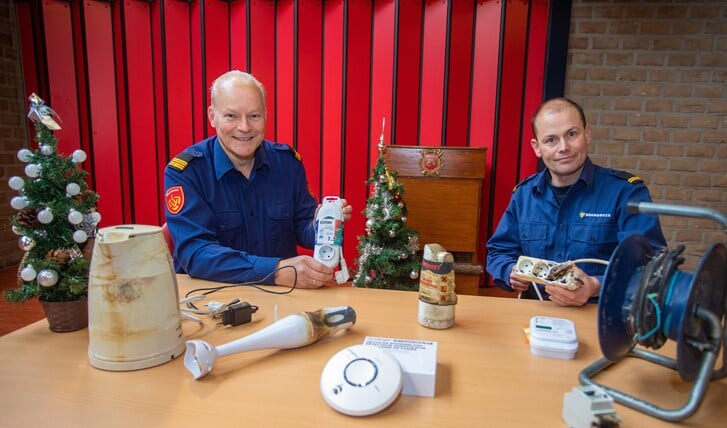 Wijkbrandweermannen Hans Schotsman (l) en Joost Schaapherder geven tips om brand te voorkomen.