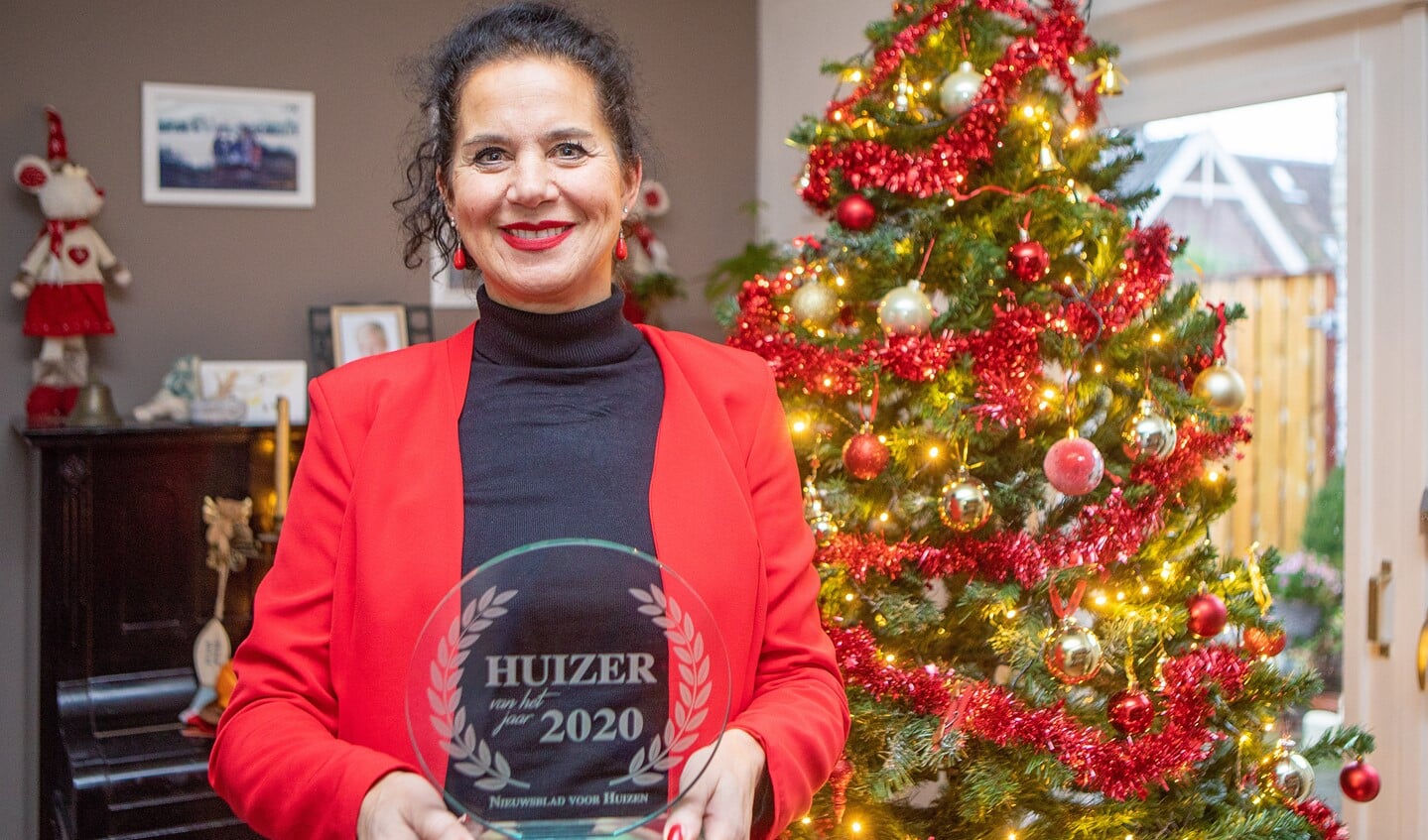 Marian van den Berge met de award die ze krijgt voor haar kaartenacties in coronatijd.