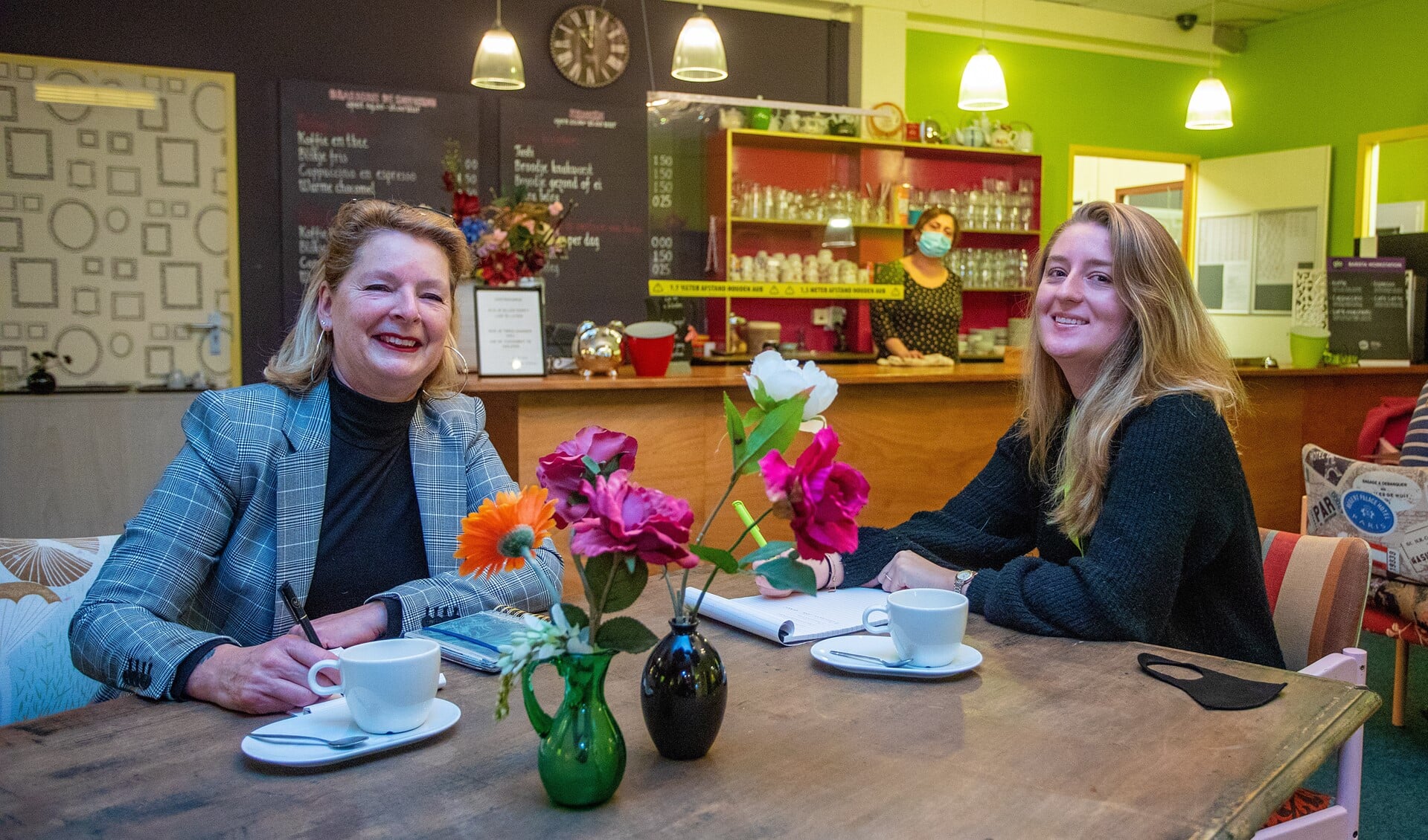 Veronika en Deanne in de huiskamer van Hèt Huis van de Buurt, waar TijdvoorMeedoen haar onderkomen heeft.