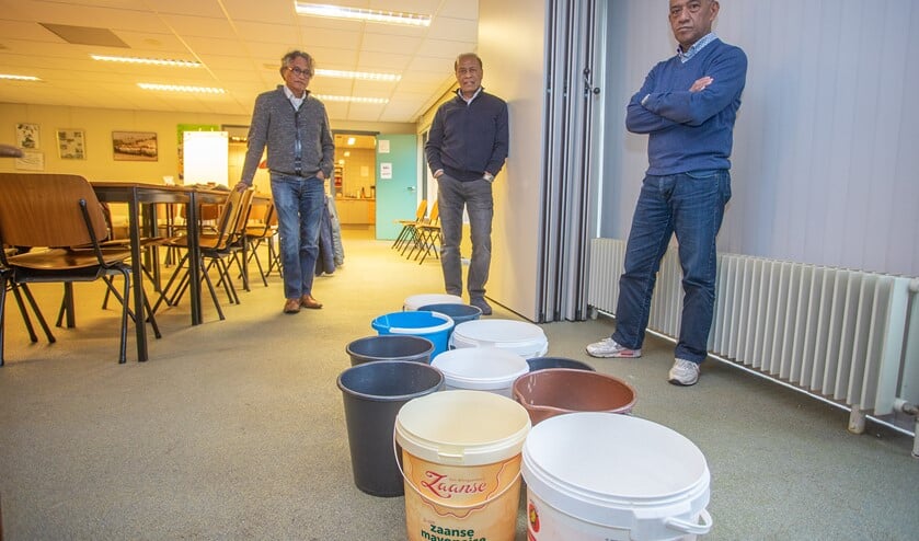 <p>Van links naar rechts: John, Nico en Mickey staan bij emmers die het regenwater moeten opvangen.</p>