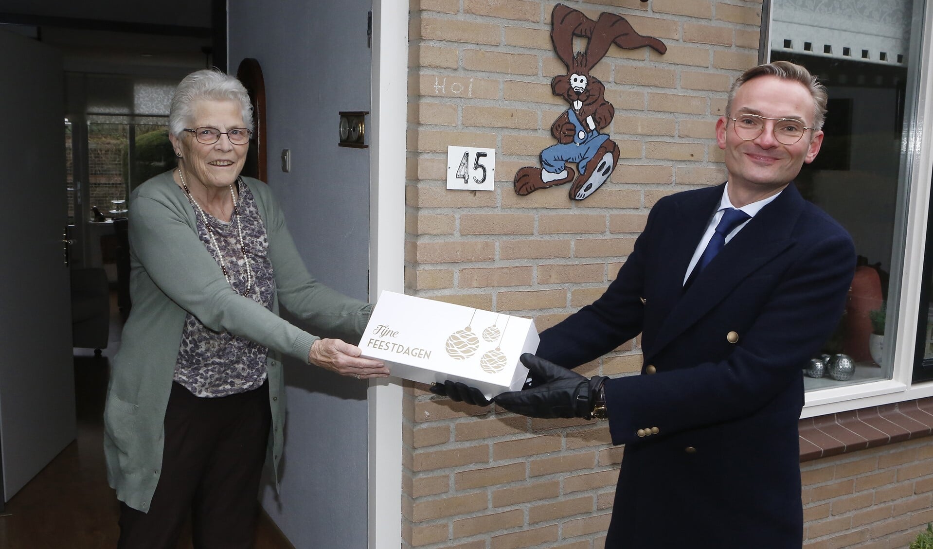 Burgemeester Nanning Mol gaf de eerste kerststol aan mevrouw De Haas,