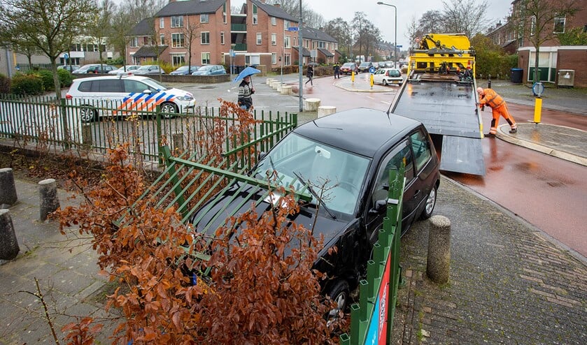<p>Een berger sleept de beschadigde auto weg.</p>