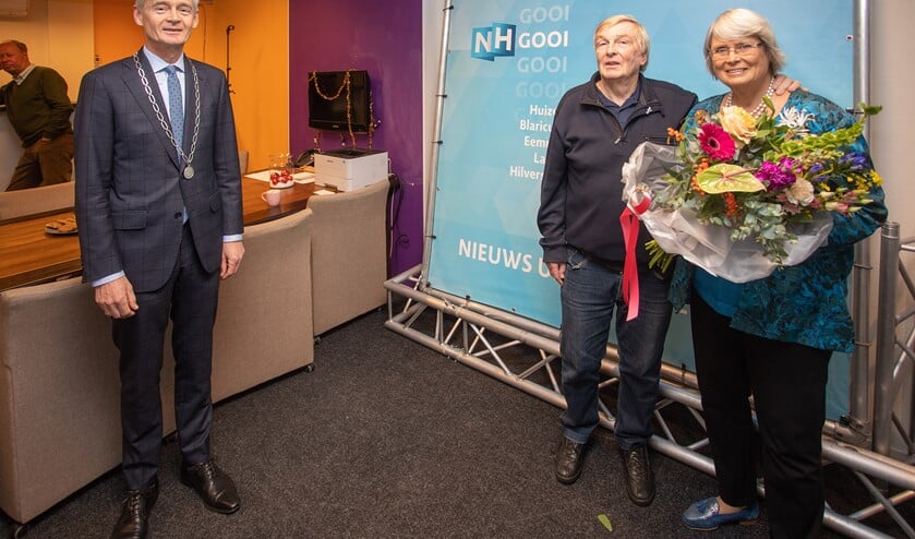 Burgemeester Niek Meijer (l) met Hans de Wildt en zijn vrouw, die hem het Huizer Insigne mocht opspelden.