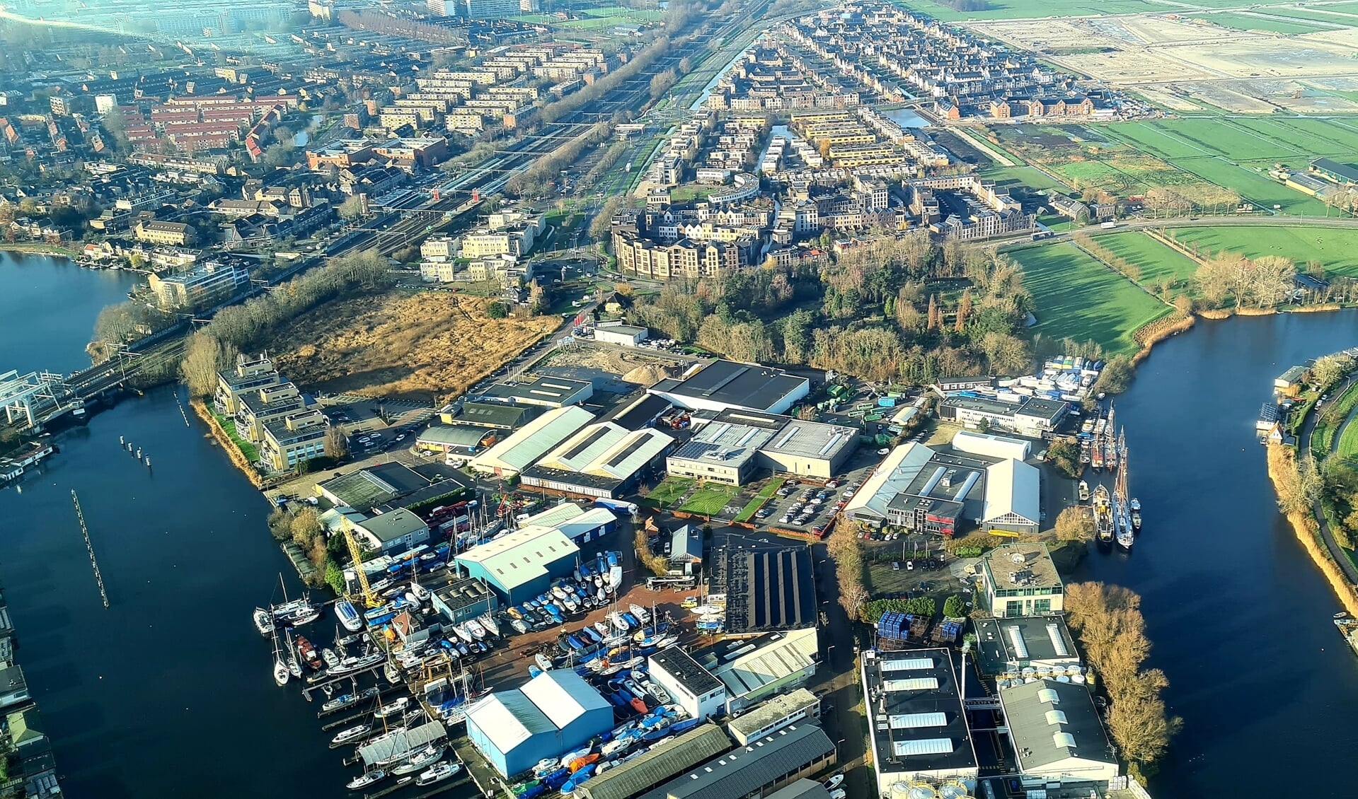 Een deel van bedrijventerrein Nijverheidslaan. De locatie waar de woningen moeten komen, is het lichtgroene veld links van het midden. Het is goed zichtbaar dat het spoor hier pal langs loopt.