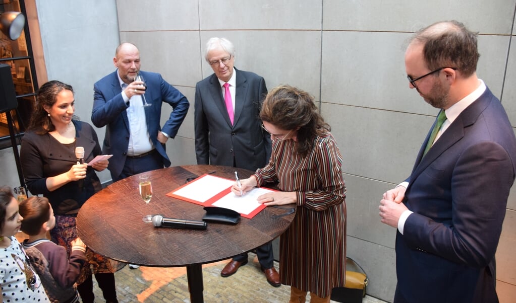 Femke Halsema ondertekent het bestuurlijk akkoord onder toeziend oog van wethouder Rutger Groot Wassink, burgemeester Bas Jan van Bochove van Weesp en wethouder Léon de Lange (vlnr).. 