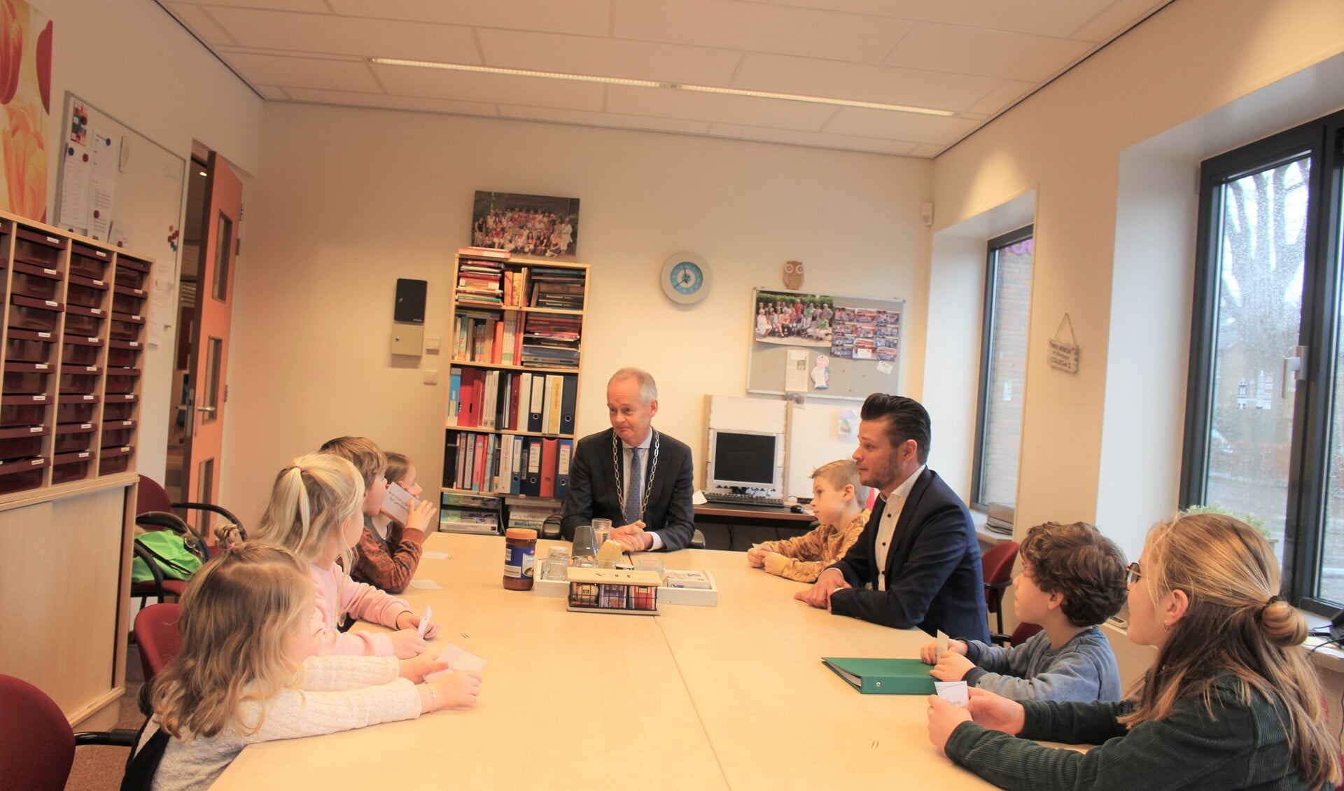 De burgemeester praat met een aantal leerlingen en locatieleider Michiel van den Brink.