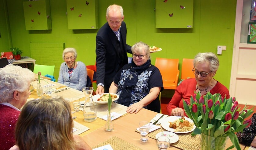Als een volleerd butler serveerde de burgemeester de maaltijden.
