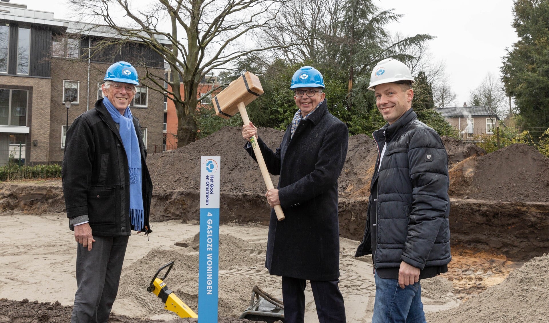 Directeur-bestuurder Maarten van Gessel (midden) bij de start van de bouw van vier sociale huurwoningen in Laren.

