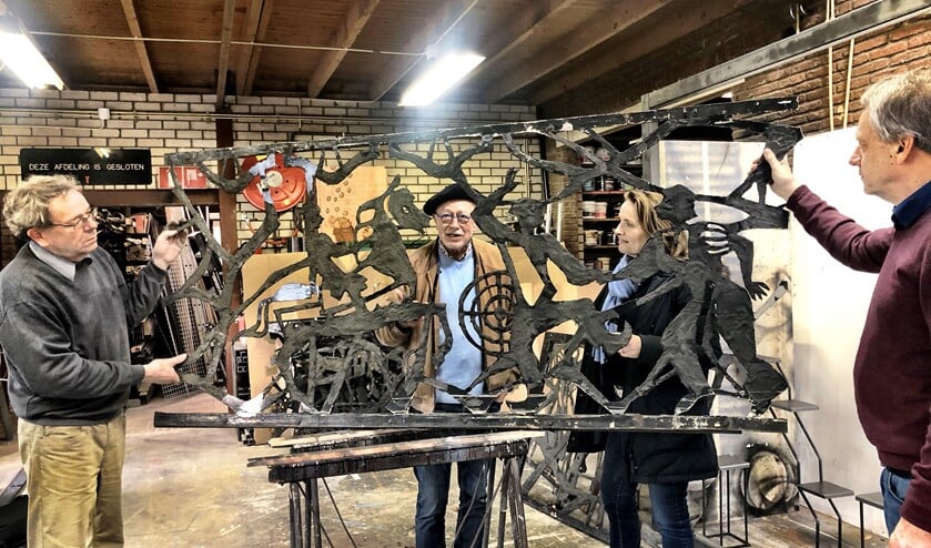 Terwijl Hans van Deuren uitleg geeft, wethouder Karin van Hunnik aandachtig luistert, houden Pim (l) en Kees Snoeij een deel van het kunstwerk vast.