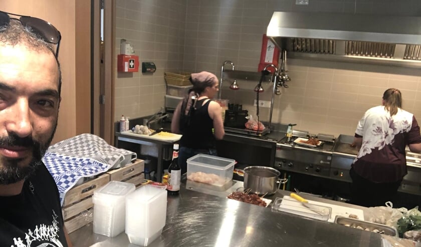 Ahmet Turkmen tijdens het koken in de keuken van het gemeentehuis.