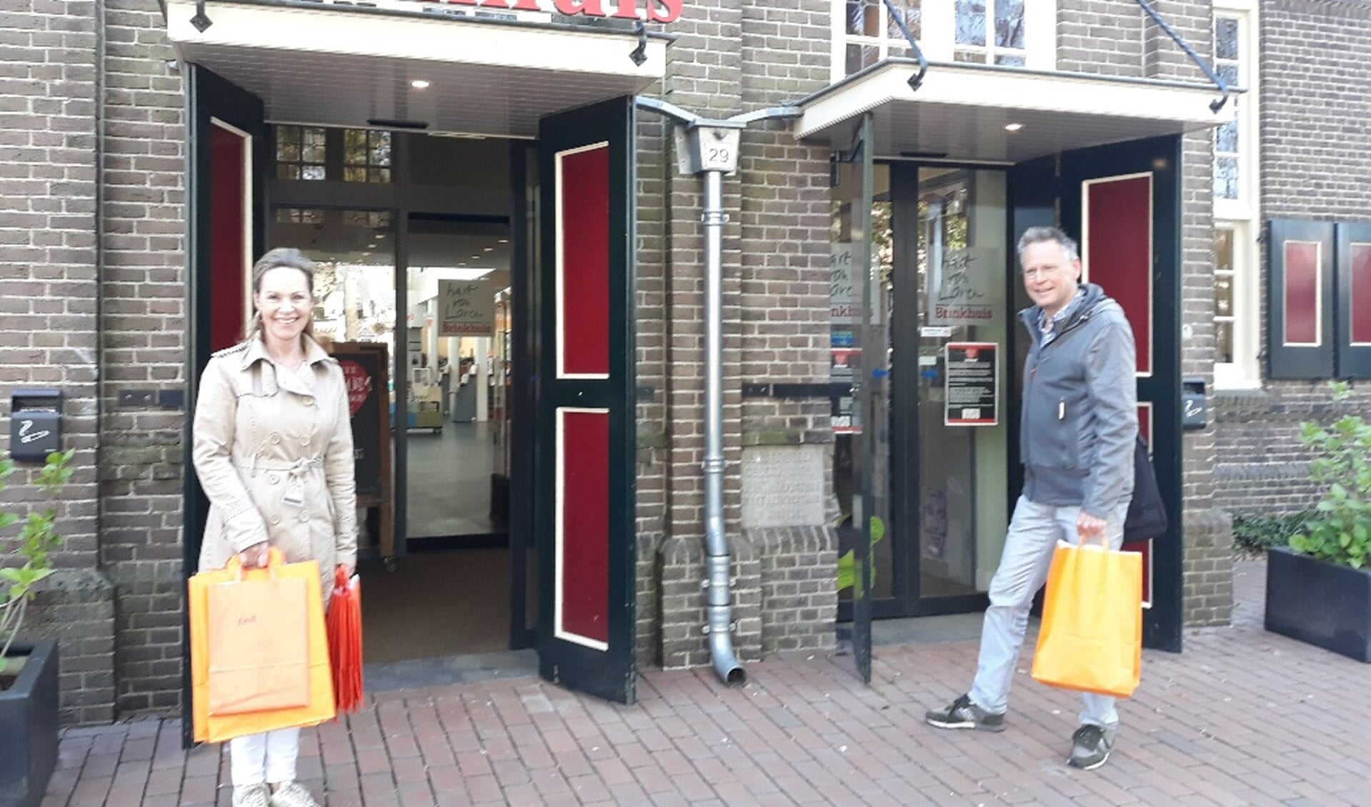 De twee vrijwilligers van Versa Welzijn BEL met hun tassen vol boeken.