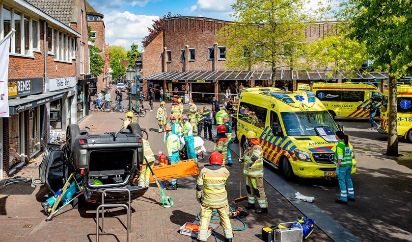 Hulpverleners ter plaatse om de beknelde bestuurder uit zijn auto te halen.