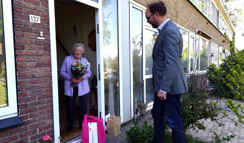 <p>Wethouder De Lange bezorgde eerder dit jaar al een boekenpakket aan een Weespse.</p>