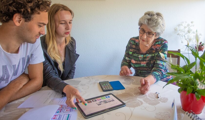 Vrijwilligers brengen een tablet bij Ditte van Doorn.