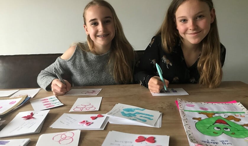 De zusjes Jinte en Fenne met hun zelfgemaakte kaarten.
