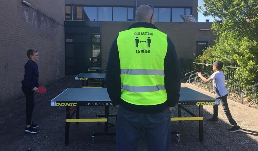 De jeugd van Tafeltennisvereniging Huizen speelt buiten.