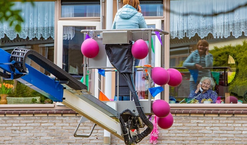 Het hele weekeinde bezoeken mensen via een hoogwerker dierbaren in Voor Anker.