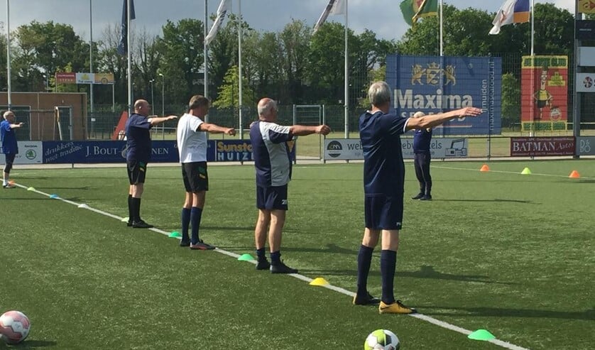 De warming-up bij Walking Football op 1,5 meter afstand van elkaar.