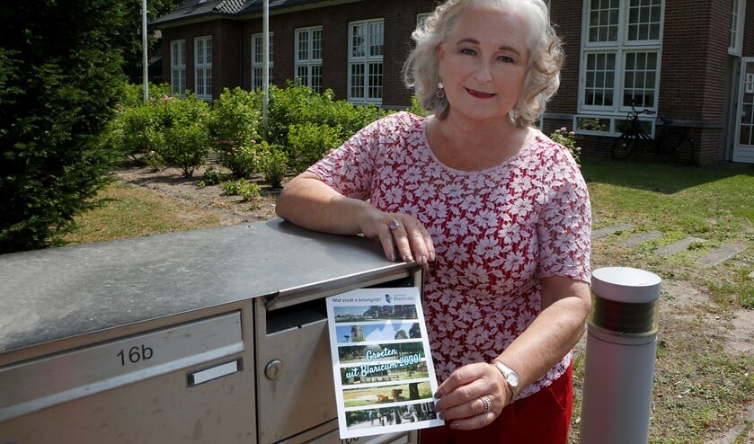 Burgemeester Joan de Zwart-Bloch met de ansichtkaart met vragen die alle inwoners krijgen.