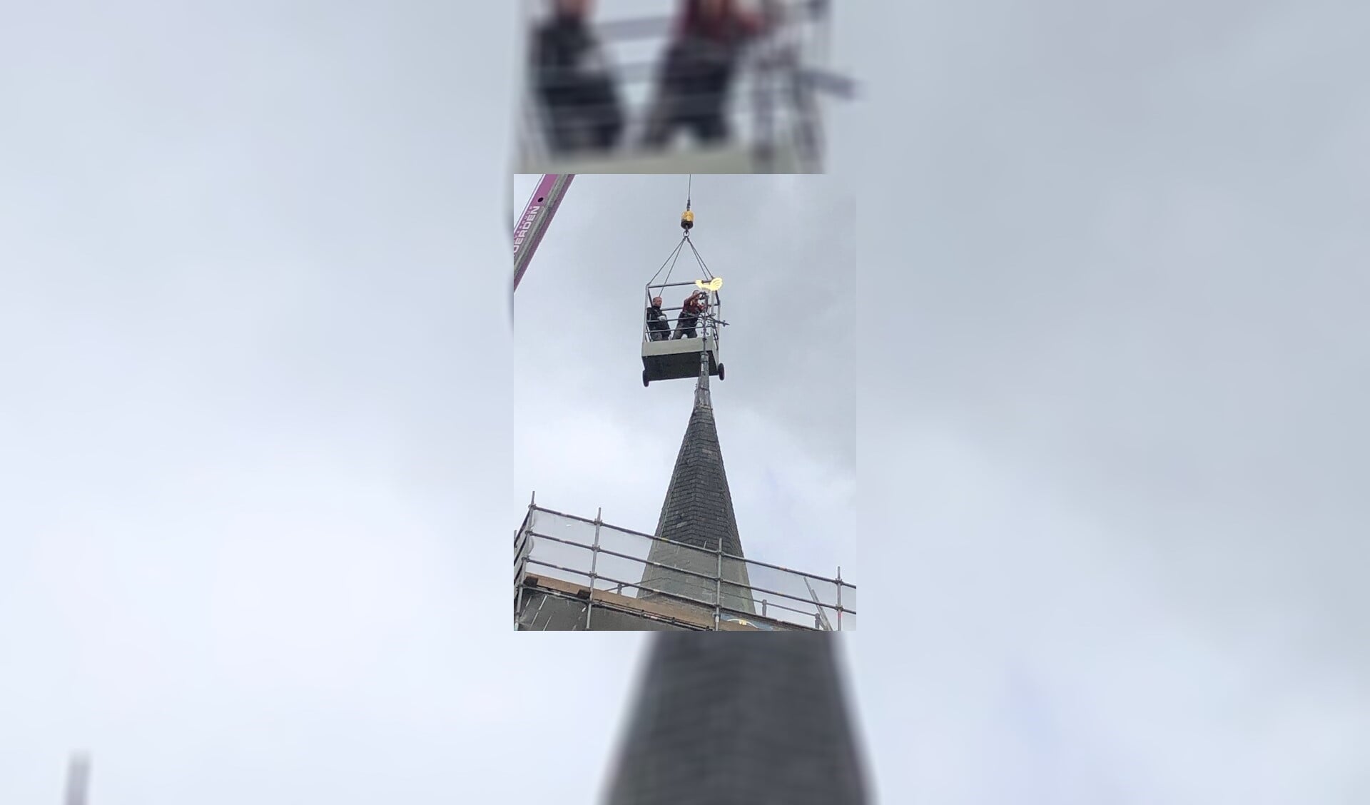 Al wiebelde de gondel door de stevige wind op 30 meter hoogte, de haan werd keurig teruggeplaatst.