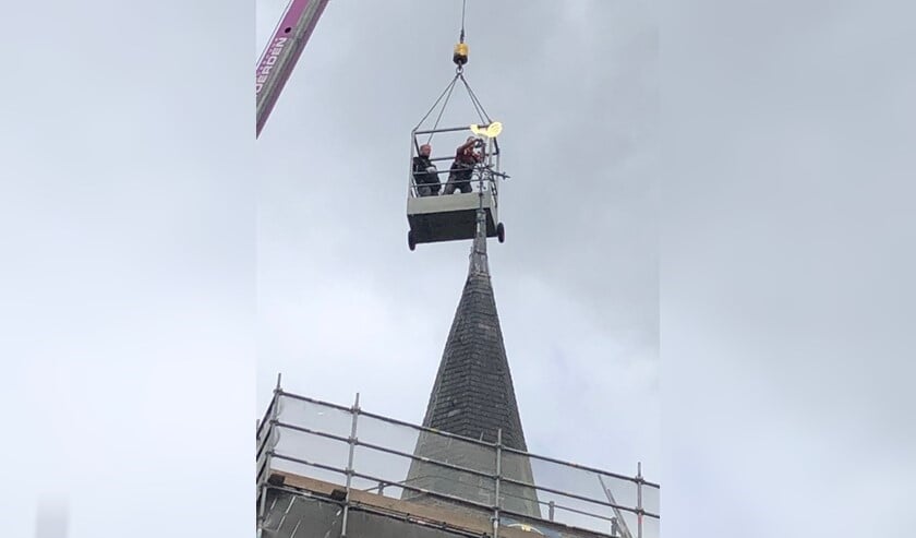 Al wiebelde de gondel door de stevige wind op 30 meter hoogte, de haan werd keurig teruggeplaatst.