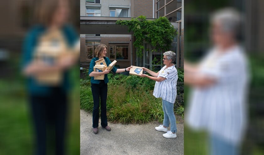 Anneke van der Veer van Versa Welzijn overhandigt de tablets aan Greet Kos.
