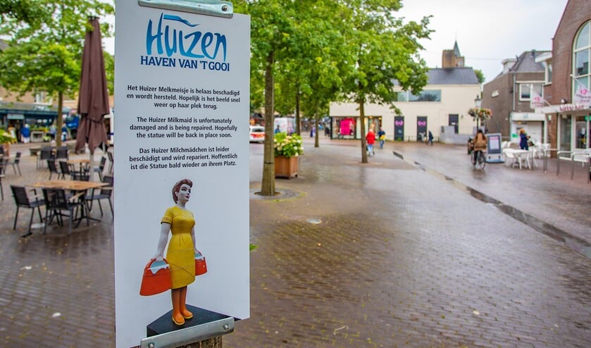 Een plaquette wijst voorbijgangers en toeristen erop dat het Huizer Melkmeisje gerepareerd wordt.
