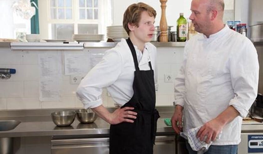 <p>Kok Robbert Jan met een van de leerlingen in de keuken van het Papagenohuis.</p>